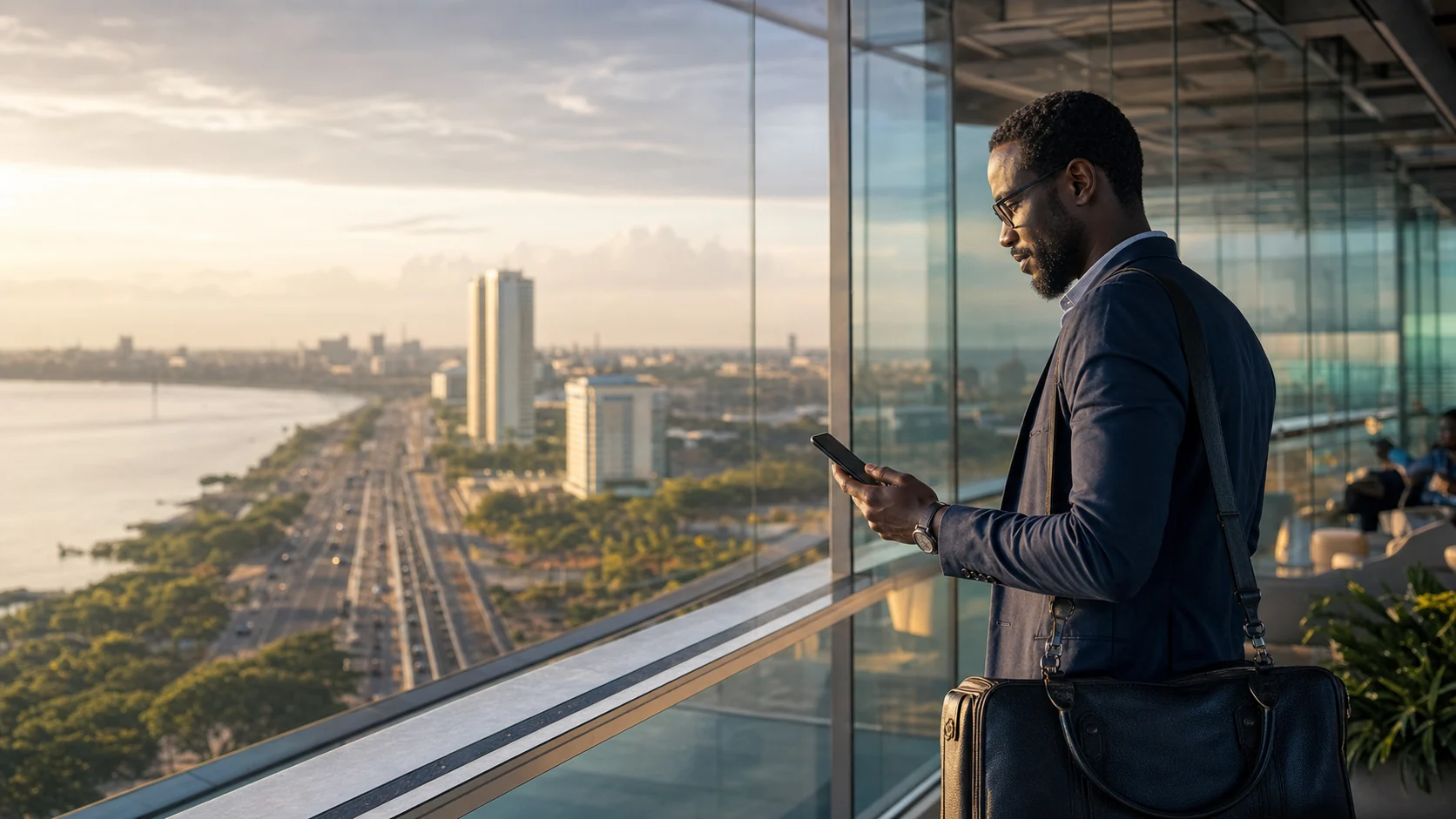 Someone checks their phone overlooking a large city by the sea.